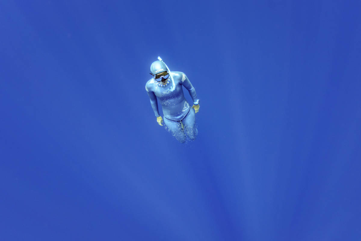 freediver ascending out of blue water